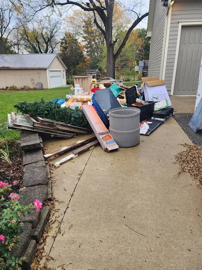 Dumpster being loaded with debris for Estate Cleanout Dumpster Rental in Bellefontaine Neighbors